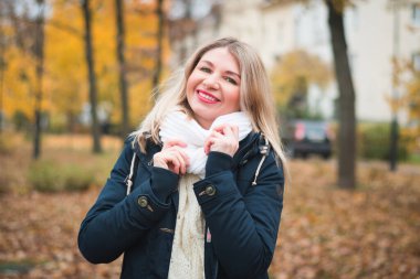 Sonbahar parkında sarı yapraklı tatlı bir kız.