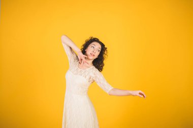 Sarı stüdyo arka planında dans eden zarif klasik balerin.