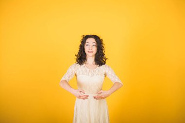 Sarı stüdyo arka planında dans eden zarif klasik balerin.