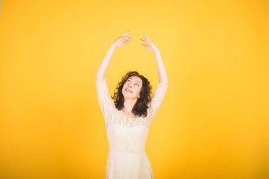 Sarı stüdyo arka planında dans eden zarif klasik balerin.