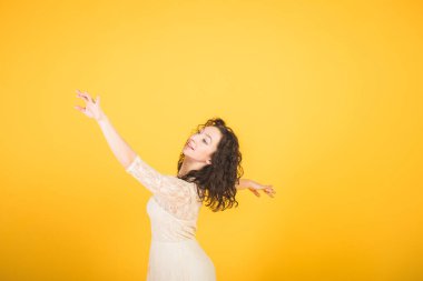 Sarı stüdyo arka planında dans eden zarif klasik balerin.