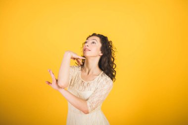 Sarı stüdyo arka planında dans eden zarif klasik balerin.