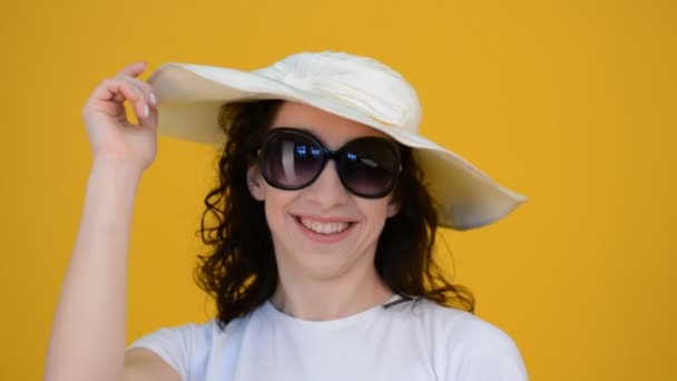 Vacker flicka porträtt med lockigt hår och en stor vit hatt — Stockvideo