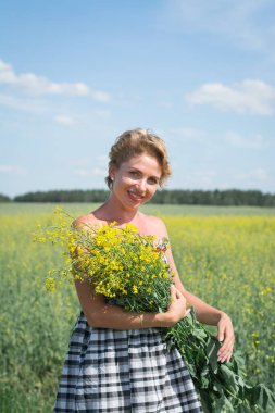 Güzel kız sıcak bir günde tarlada yürür.
