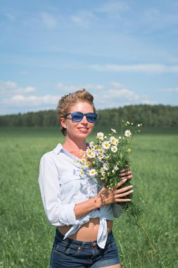 Güzel kız sıcak bir günde tarlada yürür.