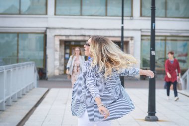 Yaşam tarzı konsepti, güzel bir kız kendi şehrinin sokaklarında dönüyor.