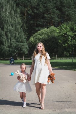 Hamile anne, dört yaşındaki kızına yaz parkında hamile kalmış.