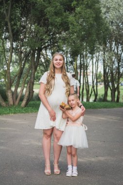 Hamile anne, dört yaşındaki kızına yaz parkında hamile kalmış.