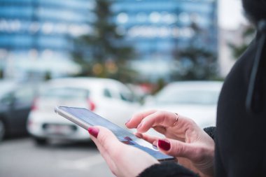 Kadın Akıllı Telefonla Mesajlaşırken Şehir Arkaplanını Kapat