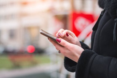 Kadın Akıllı Telefonla Mesajlaşırken Şehir Arkaplanını Kapat