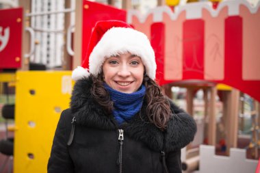 Şehir caddesinde Noel Baba şapkalı güzel bir kızın portresi.