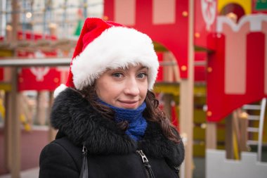 Şehir caddesinde Noel Baba şapkalı güzel bir kızın portresi.