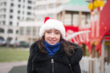 Şehir caddesinde Noel Baba şapkalı güzel bir kızın portresi.