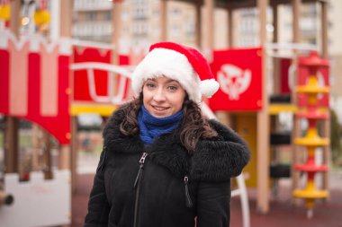 Şehir caddesinde Noel Baba şapkalı güzel bir kızın portresi.