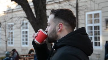 Şehirde sıcak çay ya da kahve içen bir adamın profil görüntüsü