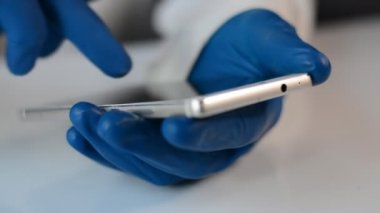 Hastanedeki doktorun elleri telefona bir mesaj yazar.