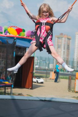 Şehir parkında salıncakta sallanan küçük bir kız