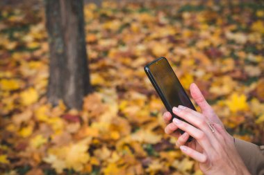 Kadın Eller kapatıyor. Cep telefonunu açık havada kullanın.