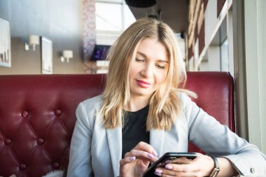 İş kadını portresi. Elinde telefon var.