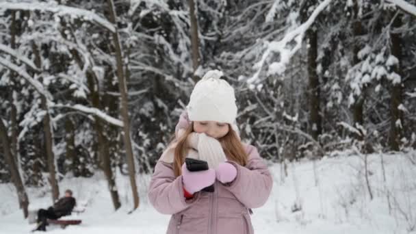 Portret dziewczynki w zimie pisze wiadomość przez telefon komórkowy — Wideo stockowe