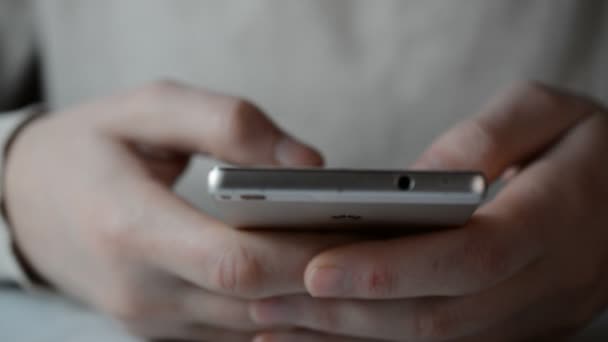 Δάχτυλα ενός νέου άνδρα γραπτών μηνυμάτων σε ένα smartphone — Αρχείο Βίντεο