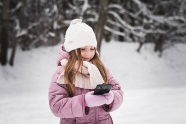 Güzel küçük kız. Beş yaşında. Kışın karlı bir şehir parkında portre.