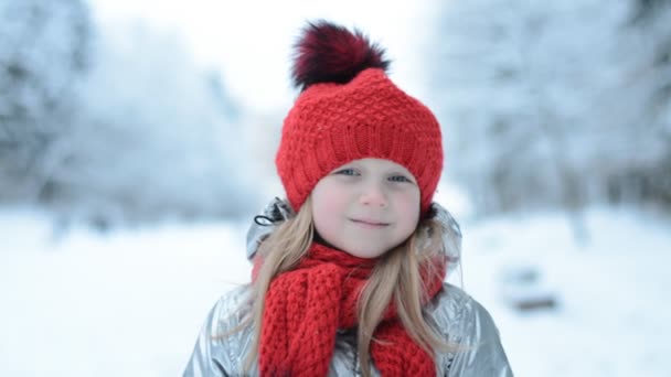 Mooi klein gelukkig meisje portret in een rode hoed in een winter stad — Stockvideo