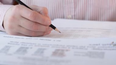Kağıt imzalama veya belge dosyalarında okumak için elinde kalem tutan bir işadamı yöneticisi