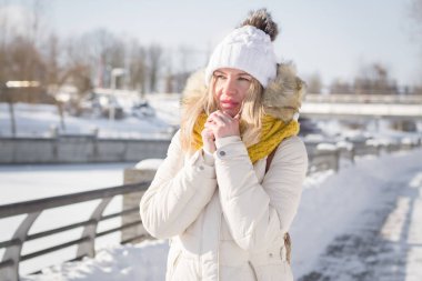 Beyaz elbiseli güzel sarışın kız kışın şehir caddesinde