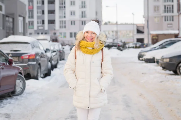 美しいですブロンド女の子で白い服で冬に街の通り — ストック写真
