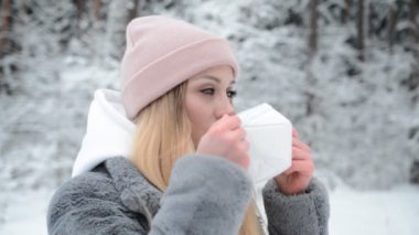 Ormandaki güzel kız portresi, koronavirüs enfeksiyonlarına karşı beyaz koruyucu bir maske takıyor.