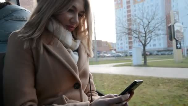 Блондинка їде в автобусі і пише повідомлення — стокове відео