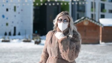 Kışın koruyucu maskeli şık bir kız modeli.