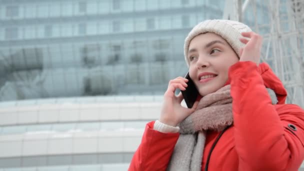 Retrato de estudante menina na primavera ou outono ou inverno contra o fundo de um edifício de vidro moderno — Vídeo de Stock