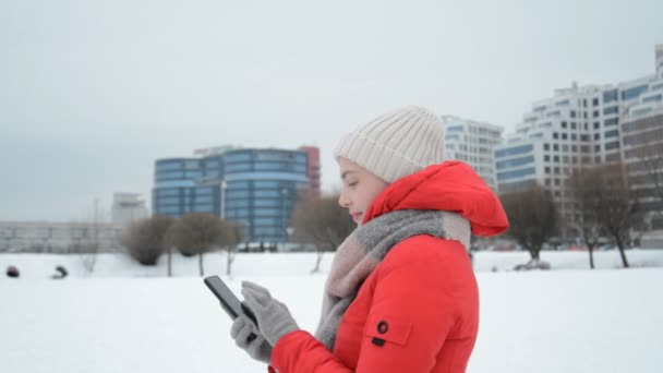 Side view of a winter girl writing a message — Stock Video