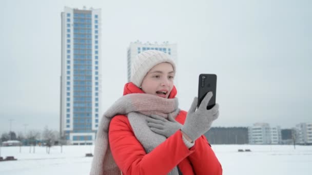 En tjej rolig talar på smartphone genom videochatt på urban bakgrund — Stockvideo