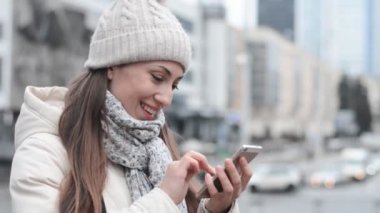 Mutlu kadın cep telefonuyla mesaj yazar ve güler.