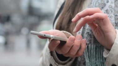 Bir kadın akıllı telefon kullanarak mesaj atıyor