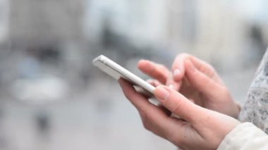 Kız telefonu açık havada kullanıyor.