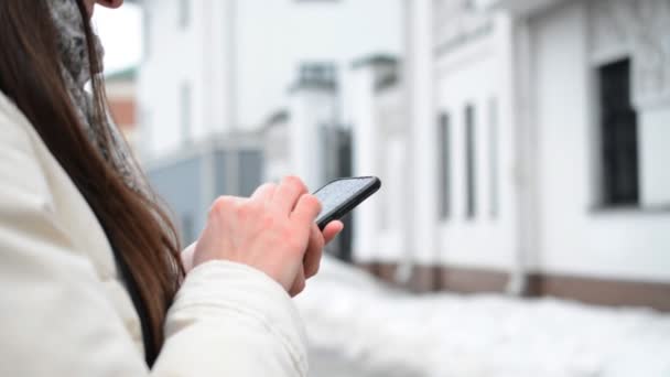 Close-up do smartphone nas mãos da mulher caucasiana e ela batendo ou mensagens de texto — Vídeo de Stock