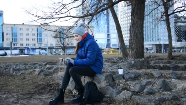 En invandrarflicka sitter på gatan i den europeiska huvudstaden — Stockvideo
