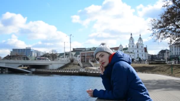 Russisch jong meisje student in een koud seizoen in het voorjaar, herfst of winter staat op straat — Stockvideo