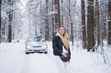 Güzel bir kızın portresi. Kışlık giysiler içinde. Ormanda.