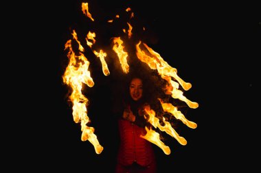 Bir kız gece bir yangın gösterisi gösterir.