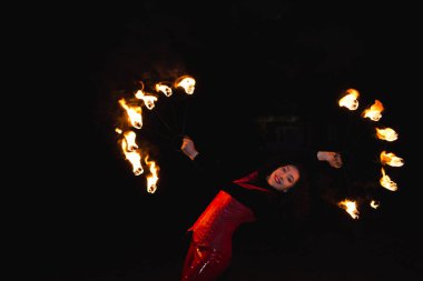Bir kız gece bir yangın gösterisi gösterir.