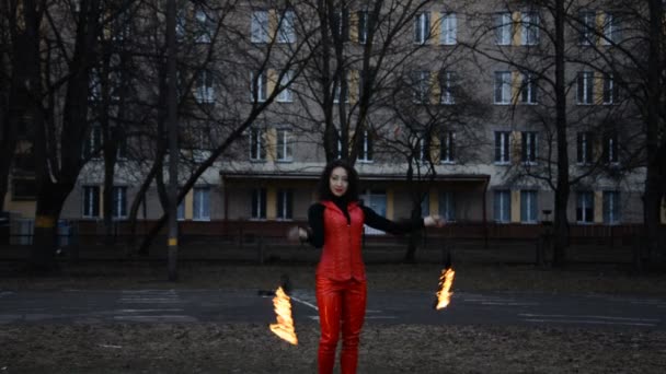 Вид спереду професійної дівчини пожежного жонглера, що виступає вночі — стокове відео