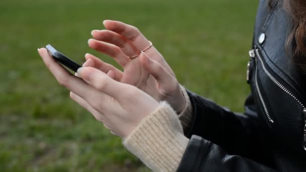 Primeros planos de las manos de la mujer utilizando el teléfono de pantalla táctil al aire libre — Vídeos de Stock