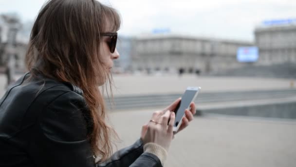 Elegante mujer caucásica uso del teléfono móvil en la calle de la ciudad — Vídeos de Stock