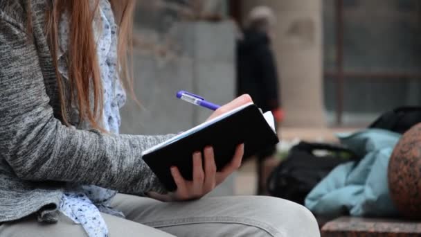 Ruka mladé ženy student dělat poznámky v notebooku — Stock video