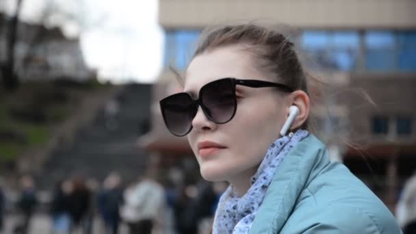 Hipster kaukasisk flicka porträtt i solglasögon har roligt och lyssnar på musik i hörlurarna — Stockvideo